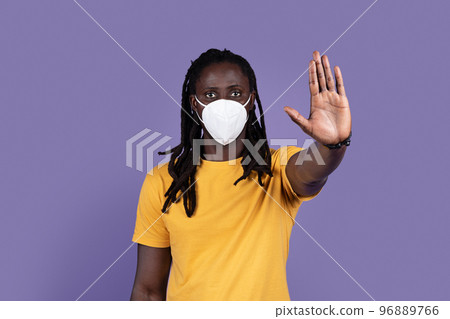 Concerned african american man with protective mask showing stop gesture Concerned african american man with protective mask showing stop gesture 96889766