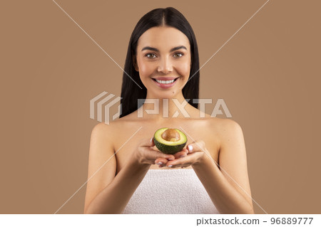 Attractive half-naked young woman holding avocado in her hands 96889777