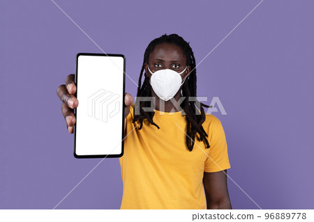 Black guy in face mask showing smartphone with empty screen 96889778