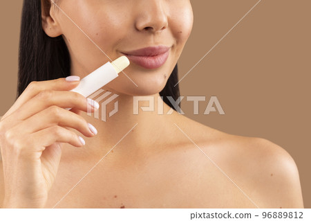 Cropped of topless woman applying lipbalm on her soft lips 96889812