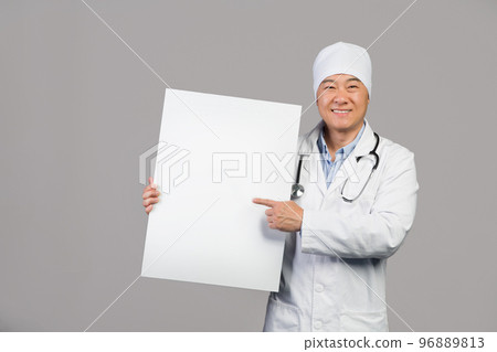 Glad mature chinese male therapist in white coat with stethoscope hold banner with copy space 96889813