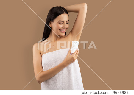 Attractive half-naked young lady with arm up using deodorant 96889833