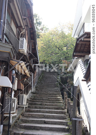 Scenery of a townscape with a forest of trees at the end of an old Japanese-style private house and stone steps Scenery of a townscape with a forest of trees at the end of an old Japanese-style private house and stone steps 96889845