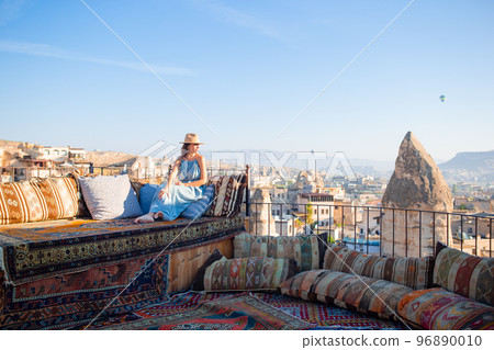 Young woman in dress on the roof with amazing view of Cappadocia in Turkey Young woman in dress on the roof with amazing view of Cappadocia in Turkey 96890010