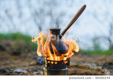 Cooking coffee in cezve on portable wood burner Cooking coffee in cezve on portable wood burner 96890244