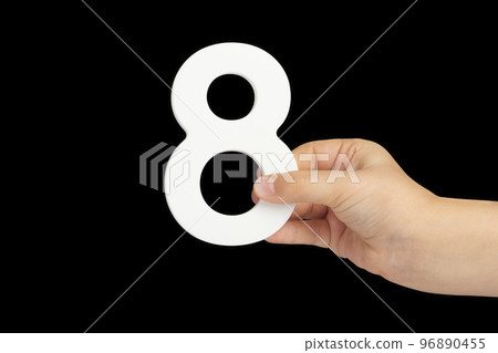Number eight in hand isolated on black background. Number 8 in a child's hand on a black background. To be inserted into a project or design. 96890455