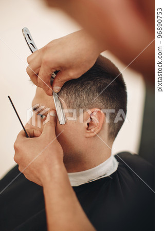 Barber shaving bearded man with retro knife 96890753