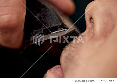 Barber shaving caucasian man in barber shop Barber shaving caucasian man in barber shop 96890767