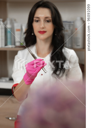 Uno spoons in the hands of a cosmetologist, tools of a cosmetologist for cleaning the face. Uno spoons in the hands of a cosmetologist, tools of a cosmetologist for cleaning the face. 96891099