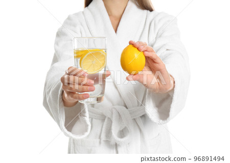 Young woman with glass of lemon water on white background, closeup 96891494