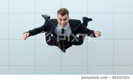 Celebrating success. Low angle view of excited young businessman keeping arms 96892091