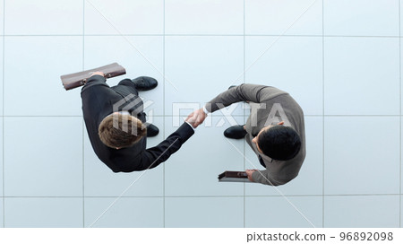 Business partners shaking hands as a symbol of unity, view from the top Business partners shaking hands as a symbol of unity, view from the top 96892098
