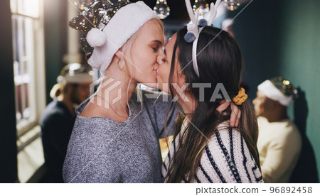Christmas, kiss and love with lesbian couple at party for celebration, festive and holiday. Lgbtq, gay and dance with women partners at xmas event for romance, social and relax at reunion gathering 96892458