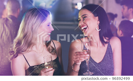Friends, drinks and party at nightclub to celebrate champagne glass, happiness and new years or birthday energy with funny conversation. Girls at club, event or disco for happy hour celebration 96892499