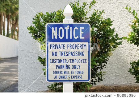 Destin, Florida- Sign with Notice Private Property No Trespassing near the bushes and wall 96893086