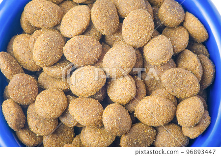 Dry food croquettes for cats or dogs in a blue bowl. Food for animals, pets. Dry food croquettes for cats or dogs in a blue bowl. Food for animals, pets. 96893447