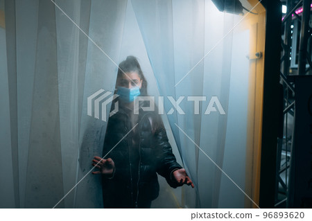 Woman at medic mask is staying in a disinfection tunnel 96893620