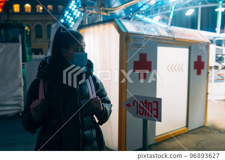 Woman in a medic mask is staying at disinfection tunnel 96893627