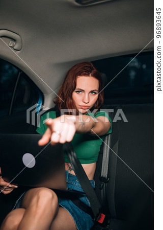 Beautiful woman is using laptop while sitting on back seat Beautiful woman is using laptop while sitting on back seat 96893645