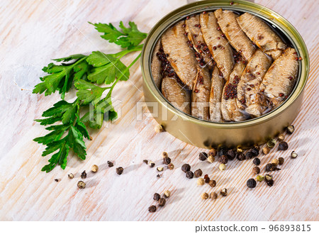 Small smoked sardines on background with greens and black pepper Small smoked sardines on background with greens and black pepper 96893815