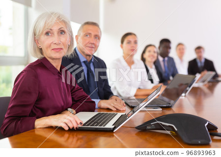Elderly business woman using laptop at business meeting Elderly business woman using laptop at business meeting 96893963
