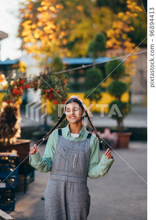 Playful farmer woman in denim overalls smiling sincerely while posing. Playful farmer woman in denim overalls smiling sincerely while posing. 96894413