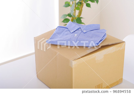 Clothing and cardboard boxes. An image of selling unwanted items and tidying up. Clothing and cardboard boxes. An image of selling unwanted items and tidying up. 96894558