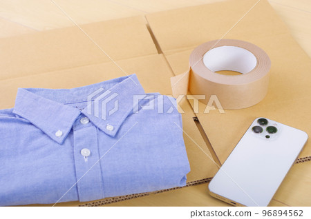 衣服和紙箱。出售不需要的物品並進行整理的圖像。 衣服和紙箱。出售不需要的物品並進行整理的圖像。 96894562