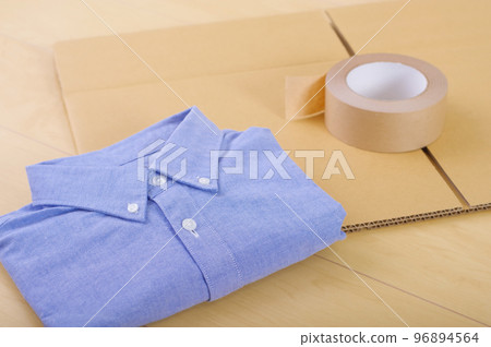 衣服和紙箱。出售不需要的物品並進行整理的圖像。 衣服和紙箱。出售不需要的物品並進行整理的圖像。 96894564