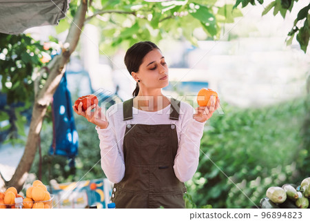 Young saleswoman holding home-grown tomatos in hands 96894823