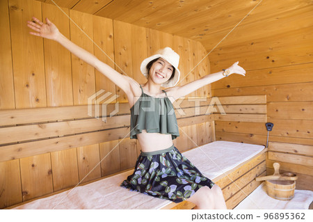 桑拿女孩戴著桑拿帽進入桑拿房 桑拿女孩戴著桑拿帽進入桑拿房 96895362