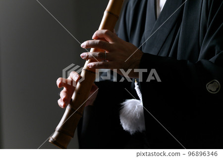 Middle-aged Japanese man playing shakuhachi faceless 96896346