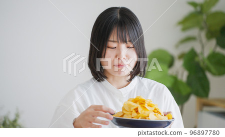 一個吃薯片的女人（不健康的飲食）.. 96897780