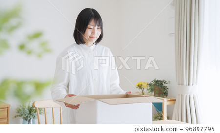 A woman who opens a cardboard (moving/packing) A woman who opens a cardboard (moving/packing) 96897795