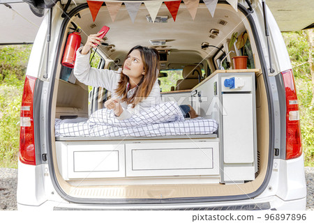 Asian woman using mobile phone inside the campervan 96897896