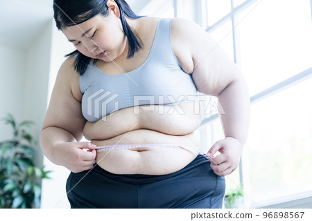 一個女人測量腰圍 96898567