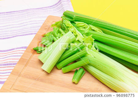 Fresh Celery Stem and Chopped Celery Sticks on Wooden Cutting Board Fresh Celery Stem and Chopped Celery Sticks on Wooden Cutting Board 96898775