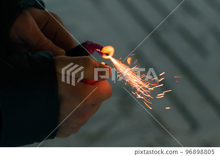 Burning Firecracker with Sparks. Guy Holding a Petard in a Hand 96898805