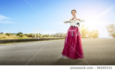 Asian woman wearing a traditional Korean national costume, Hanbok, standing on the street 96899102