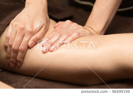 一位女士正在大腿上進行精油按摩。 一位女士正在大腿上進行精油按摩。 96899198
