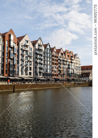 Modern buildings on Granary Island over the Motlawa River in Old Town. Abstract structure. Creative photo Tourism on the Motlawa River. New Apartments architecture glass windows with reflections Modern buildings on Granary Island over the Motlawa River in Old Town. Abstract structure. Creative photo Tourism on the Motlawa River. New Apartments architecture glass windows with reflections 96900778