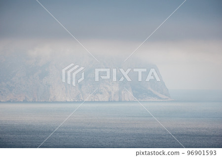 Timelapse of fluffy clouds moving in dark cloudy sky over calm sea and volcanic rocky shores. Abstract aerial nature summer ocean sunset sea and sky background. Horizon. Nobody. Vacation and travel 96901593