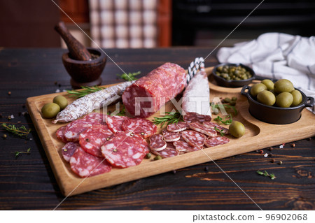 Traditional Spanish fuet salami sausage on wooden cutting board at domestic kitchen 96902068