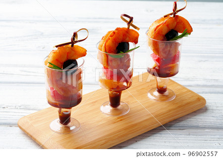Snacks with shrimp in glass cups on the banquet table for a buffet Snacks with shrimp in glass cups on the banquet table for a buffet 96902557