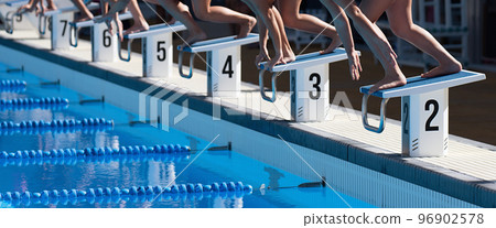 Swimmers on the starting block with only hands and feet visable Swimmers on the starting block with only hands and feet visable 96902578