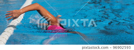 Swimmer woman athlete swimming in pool lanes doing a crawl lap. Swim race freestyle. Triathlete training for triathlon 96902593