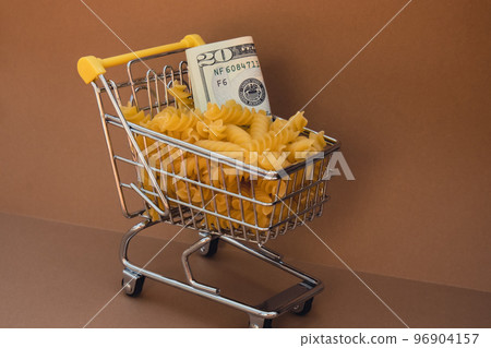 Shopping trolley cart Filled With Pasta with 20 US dollar paper money banknote on Beige background. Copy space for your text. Food and groceries shopping price increase, Rising food cost food crisis 96904157