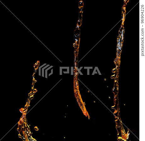 Orange, lemon juice or oil lubricant splash, liquid gold yellow drink drops. Fruit beverage water elements in line form . Fresh splashing and flowing jets, black background isolated freeze motion Orange, lemon juice or oil lubricant splash, liquid gold yellow drink drops. Fruit beverage water elements in line form . Fresh splashing and flowing jets, black background isolated freeze motion 96904226