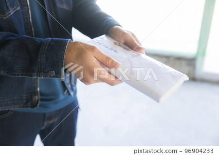 A male worker handing a greeting towel and greeting at the work site A male worker handing a greeting towel and greeting at the work site 96904233