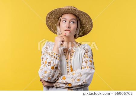 Ukrainian pensive woman on yellow background. Smart thinking student girl finding answer gesture or Ukrainian pensive woman on yellow background. Smart thinking student girl finding answer gesture or 96906762